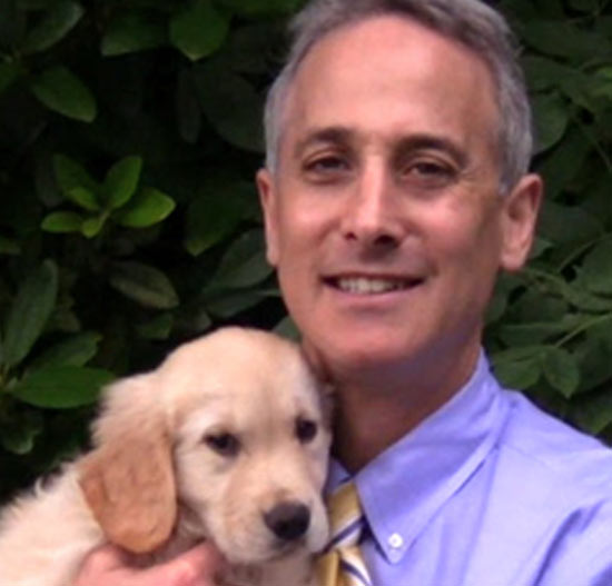 A man holding a puppy in his hand.